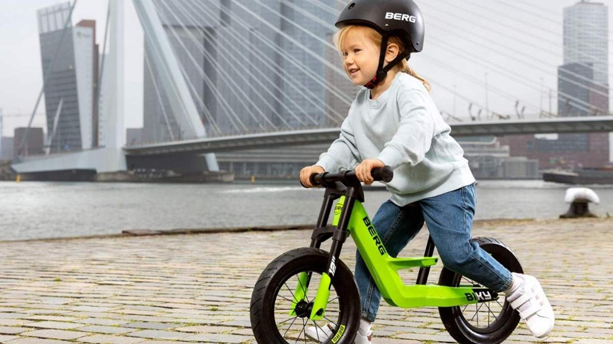 Kind fährt auf grünem Biky