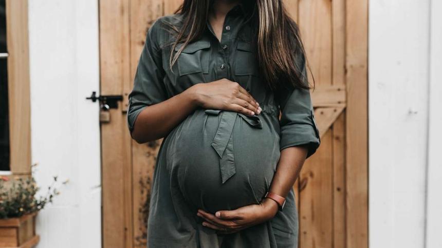 Eine schwangere Frau hält ihren Babybauch