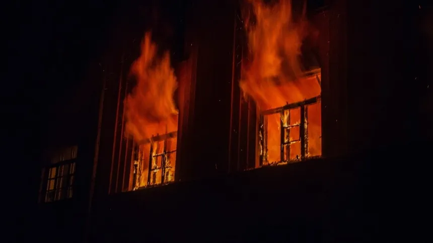 Aus dem Fenster eines Gebäudes lodern Flammen