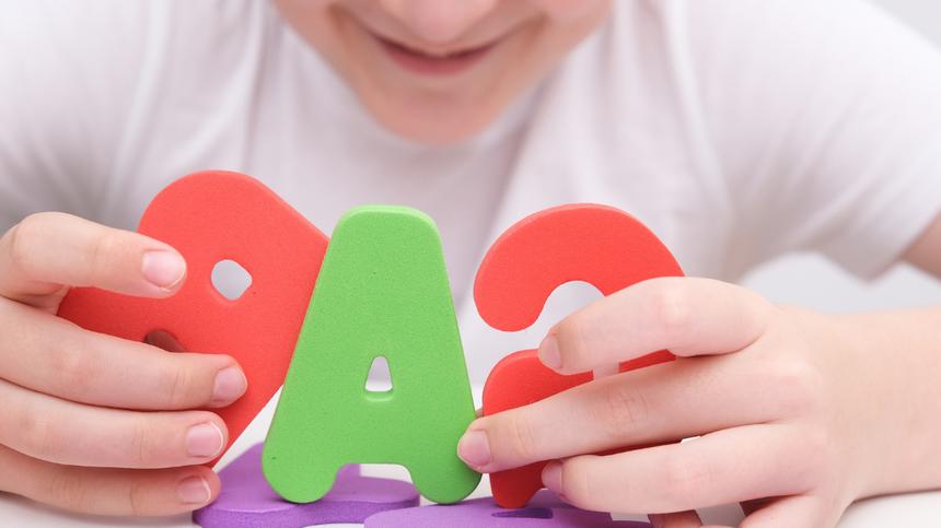Kind legt Spielzeugbuchstaben