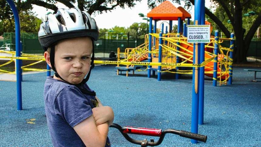 Kind mit Helm auf dem Kopf, schaut böse in die Kamera