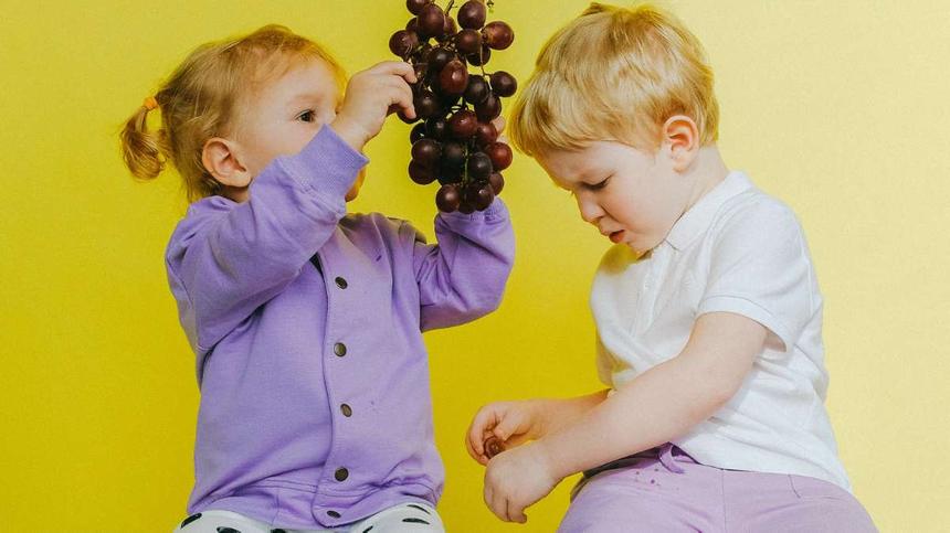 Symbolbild: Kinder probieren rote Trauben