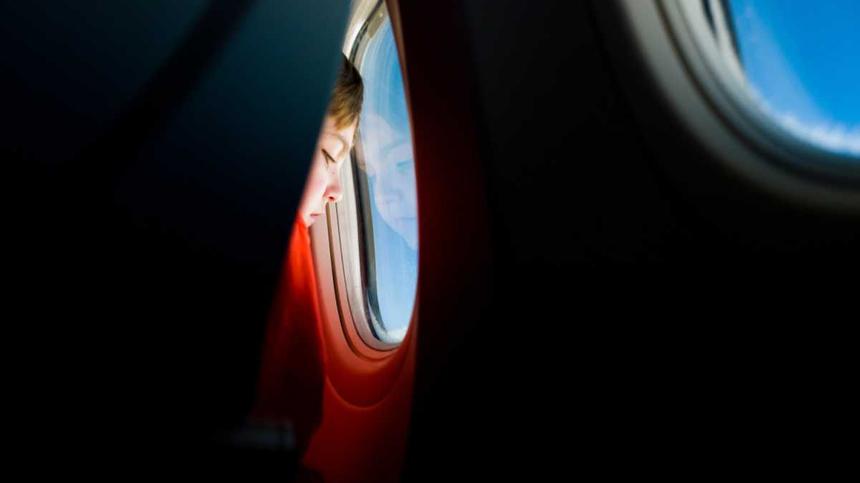 Kind schaut aus einem Flugzeugfenster