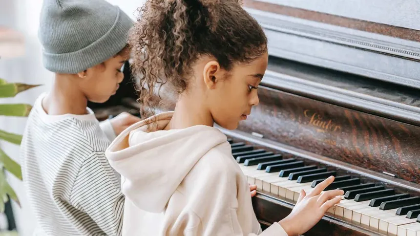 Symbolbild: Kinder spielen zusammen am Klavier