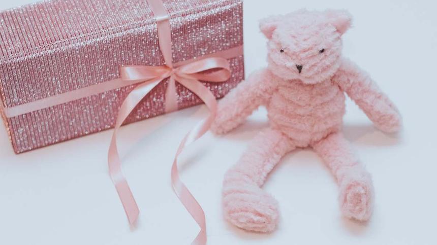 Geschenk in rosa Geschenkpapier und kleiner Teddy
