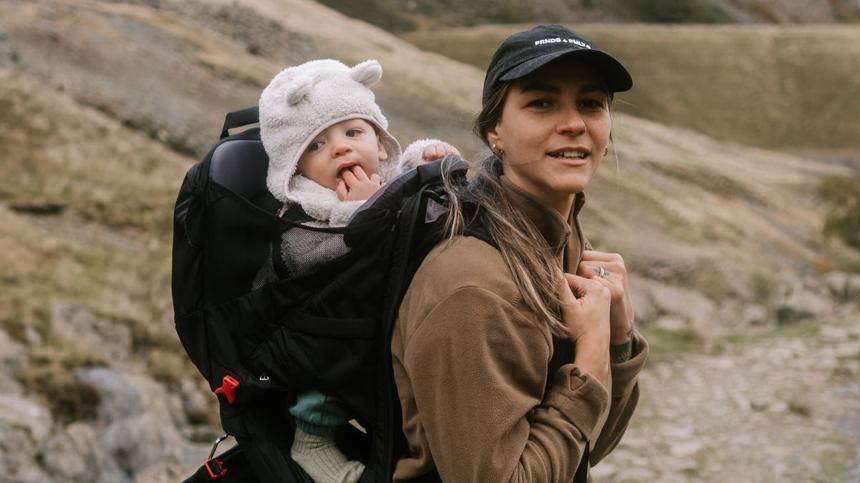 Mutter und Baby wandern in den Bergen