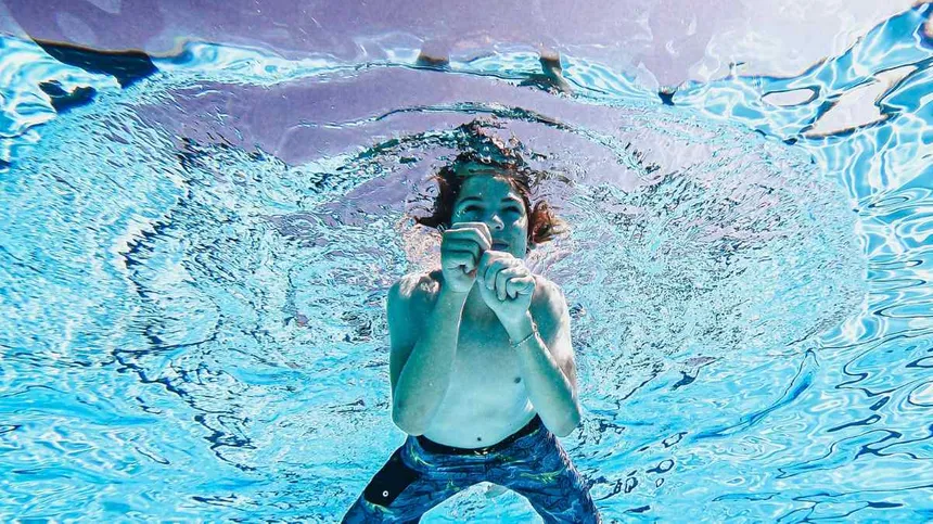 Kind allein im Freibad unter Wasser