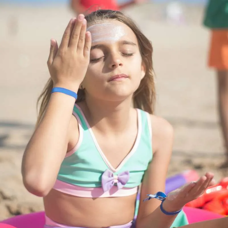 Symbolbild: Kind benutzt mangelhafte Sonnencreme