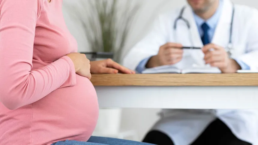 Schwangere sitzt beim Arzt: Schwangerschaftsvorsorge